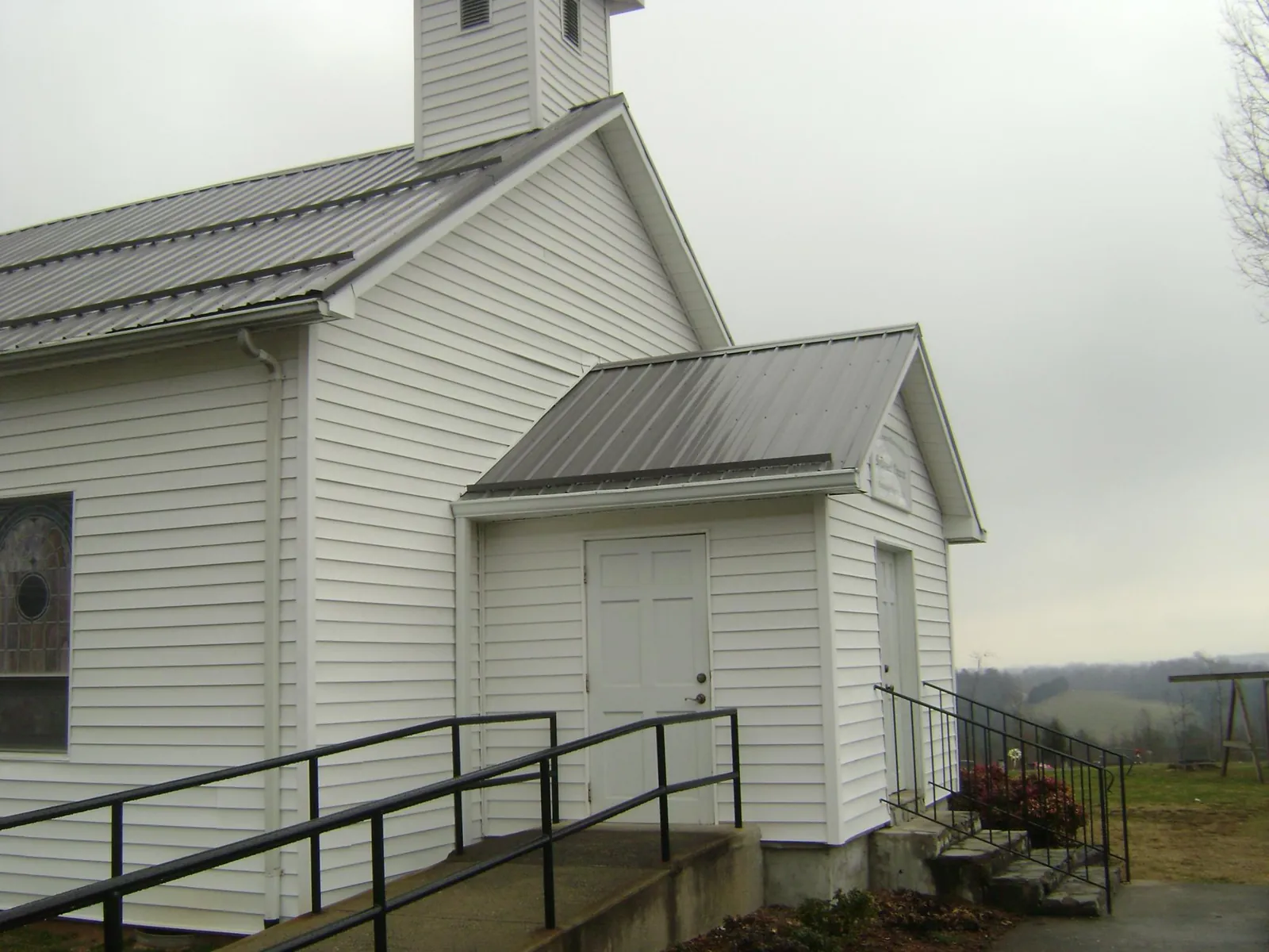 Gray metal roof on a white clapboard church with a steeple in Bern